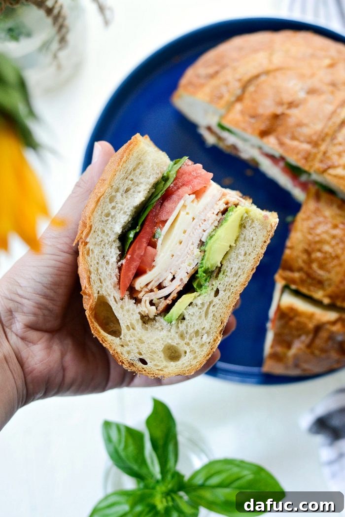 Golden State Club Loaf 2 Delicious California Club Loaf Sandwich, perfect for summer picnics and beach days. Features avocado, bacon, chicken deli meat, havarti, tomato, and fresh basil.