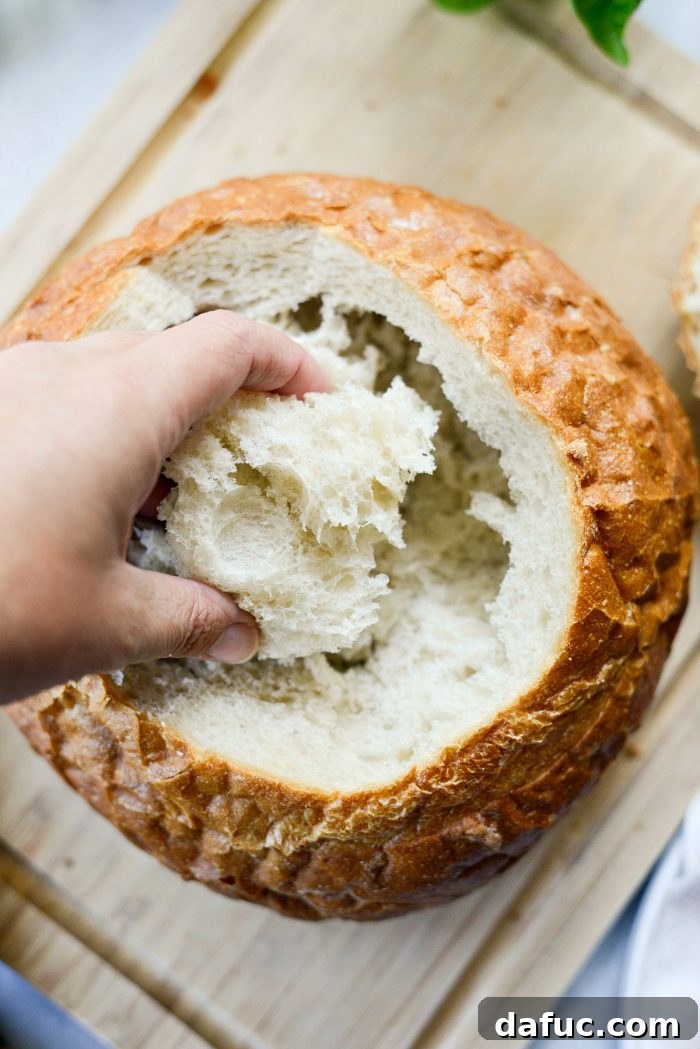 Cutting the top off the bread boule at an angle to create a lid.