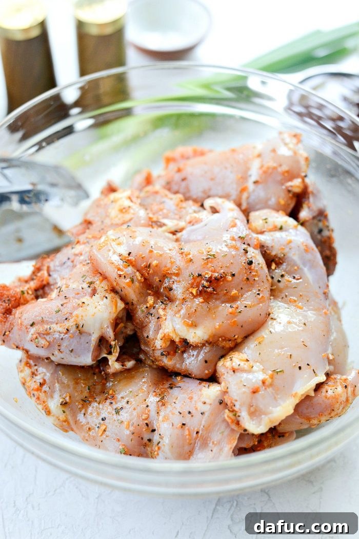 Zesty BBQ Chicken Slaw Summer Bowl 6 Chicken thighs being seasoned with olive oil and spices in a bowl