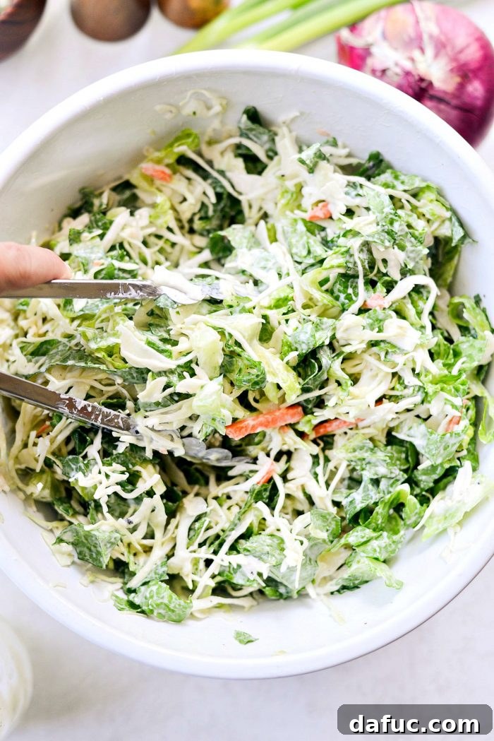 Zesty BBQ Chicken Slaw Summer Bowl 10 Greek yogurt coleslaw dressing being poured over salad greens