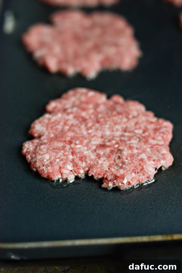 Mac Mini Bites 12 Beef patties griddling on a hot electric griddle, achieving a crispy sear.