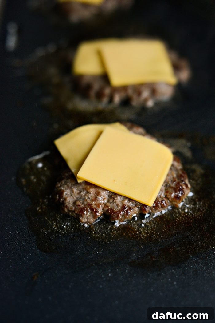 Mac Mini Bites 13 Griddled beef patties topped with squares of American cheese, melting beautifully.