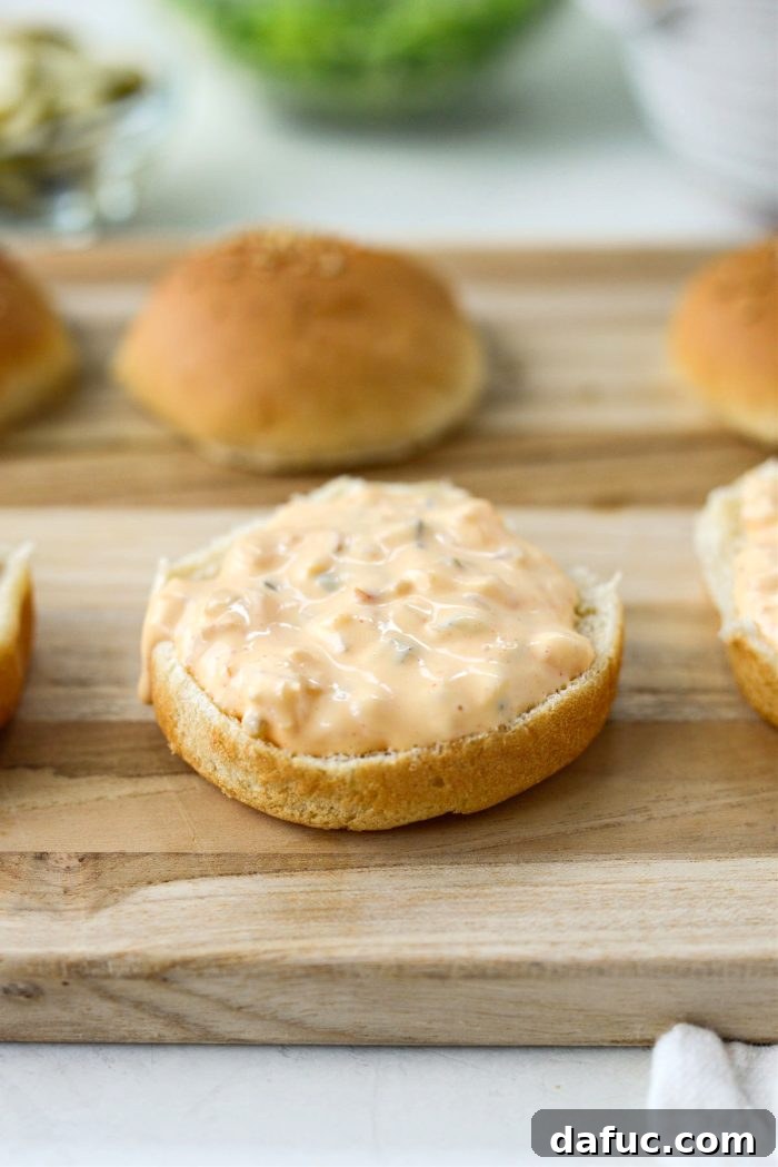 Mac Mini Bites 16 A spoonful of homemade Mac sauce spread on the bottom half of a slider bun.
