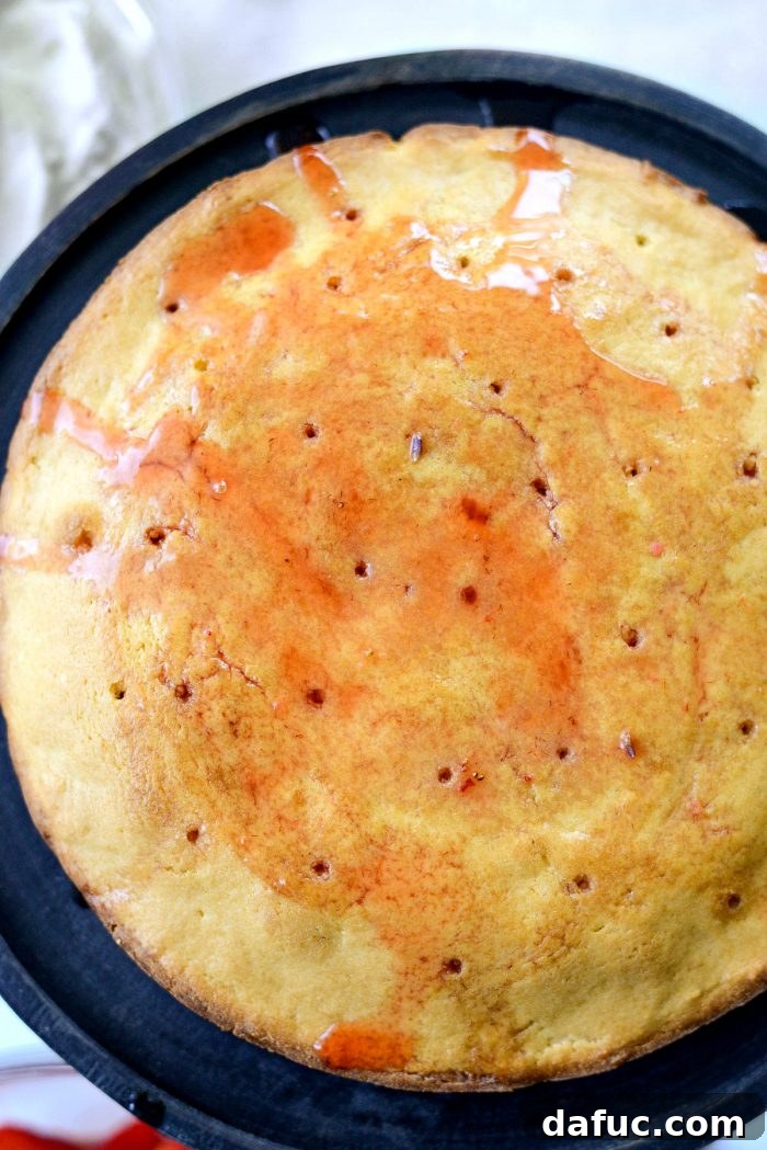 Fresh Strawberry Shortcake 21 Spoon drizzling macerated strawberry liquids over a poked pound cake layer.