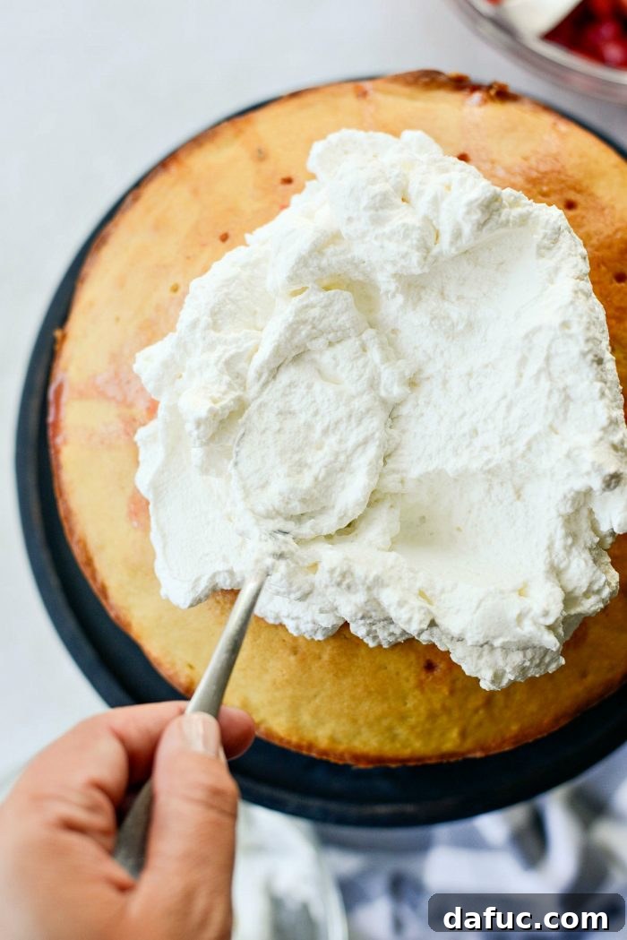 Fresh Strawberry Shortcake 22 Spreading a generous layer of homemade whipped cream over the first pound cake layer.
