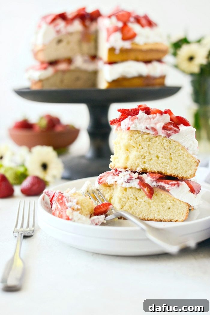 Fresh Strawberry Shortcake 30 A slice of Strawberry Shortcake Cake being cut, revealing the moist cake, creamy whipped cream, and juicy strawberries.