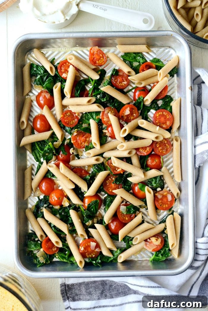 Mediterranean Sheet Pan Pasta Frittata 10 Close-up of spooning ricotta cheese onto the frittata mixture.
