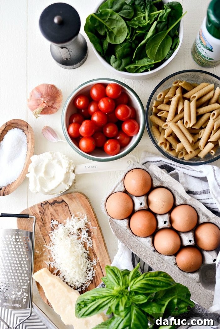 Mediterranean Sheet Pan Pasta Frittata 4 Ingredients for Sheet Pan Spinach Tomato Ricotta Pasta Frittata laid out on a cutting board.