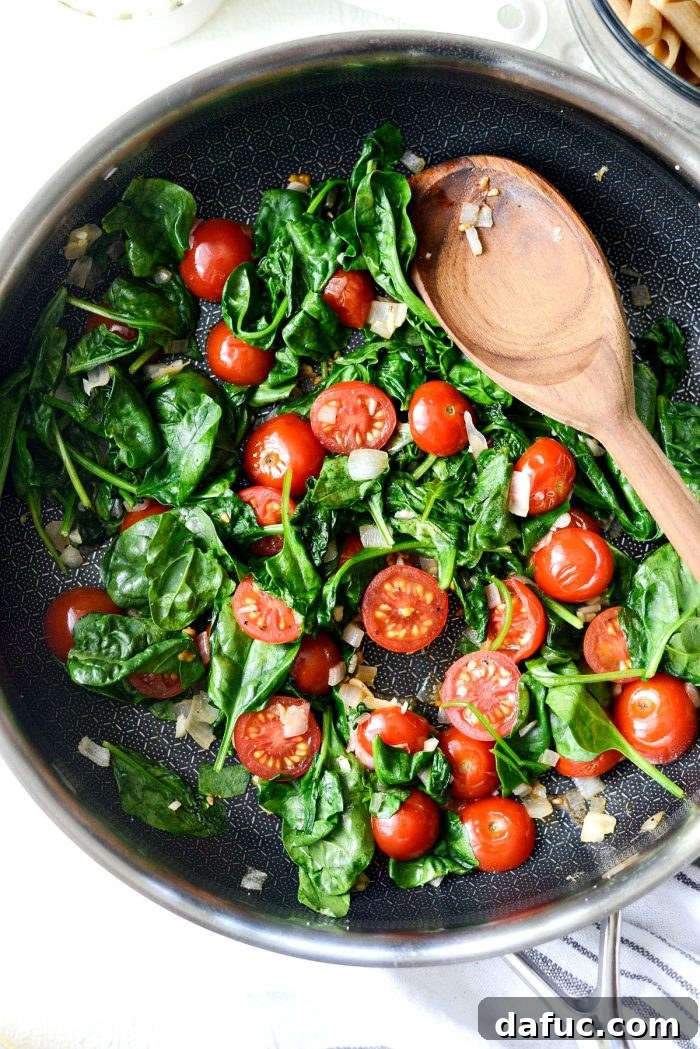Mediterranean Sheet Pan Pasta Frittata 7 Pouring egg mixture over vegetables and pasta on a sheet pan.