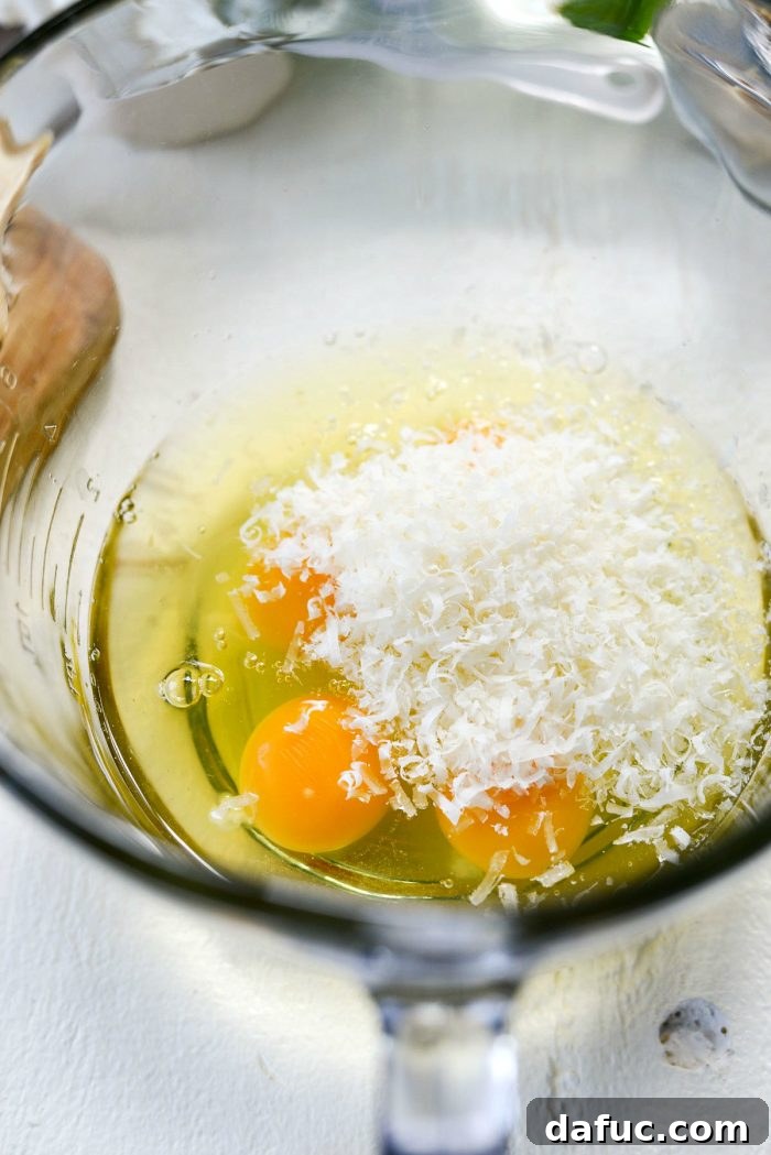 Mediterranean Sheet Pan Pasta Frittata 8 Whisking eggs with Parmesan cheese in a bowl.