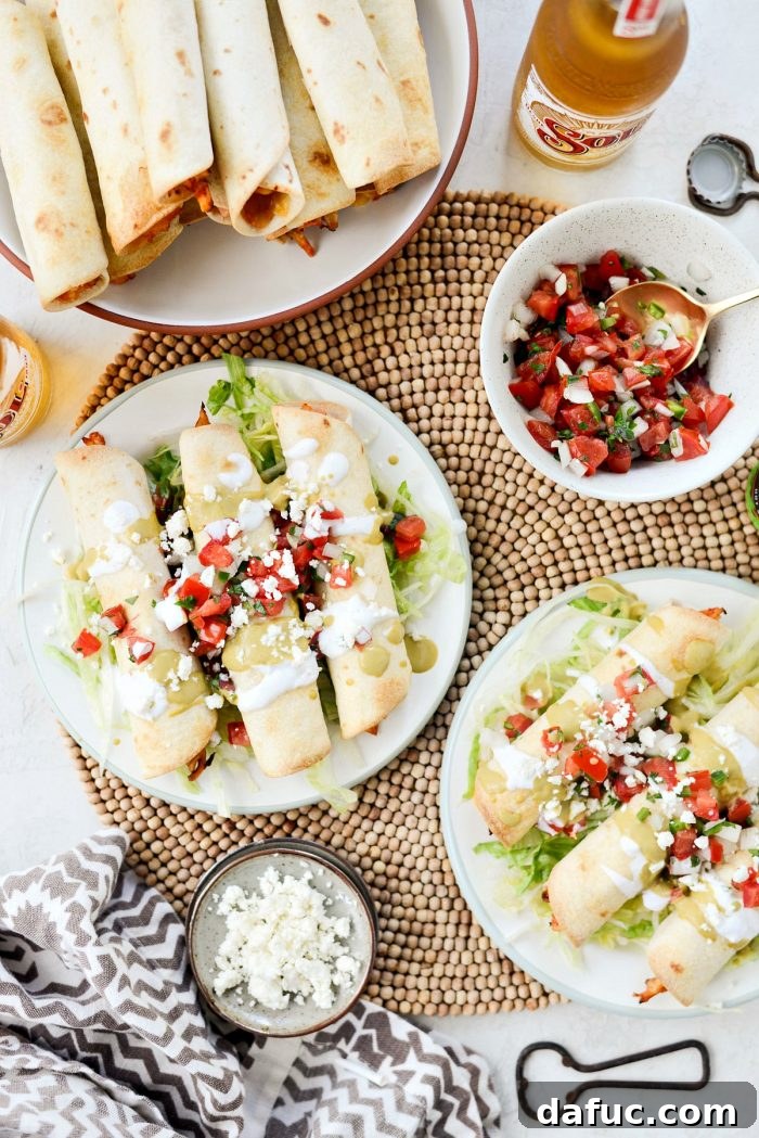 Zesty Air Fryer Salsa Chicken Taquitos 13 Plated Air Fryer Salsa Chicken Taquitos with various fresh toppings like lettuce, pico de gallo, and sour cream
