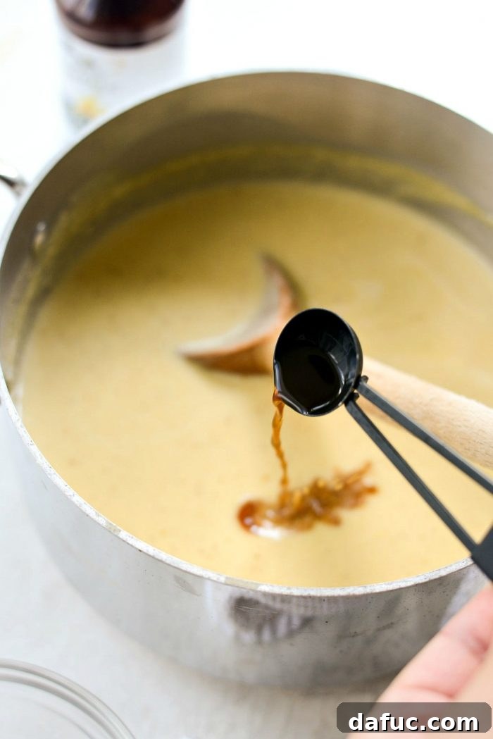 Golden Brown Butter Indulgence 14 Whisking pure vanilla extract into the thickened ice cream base.