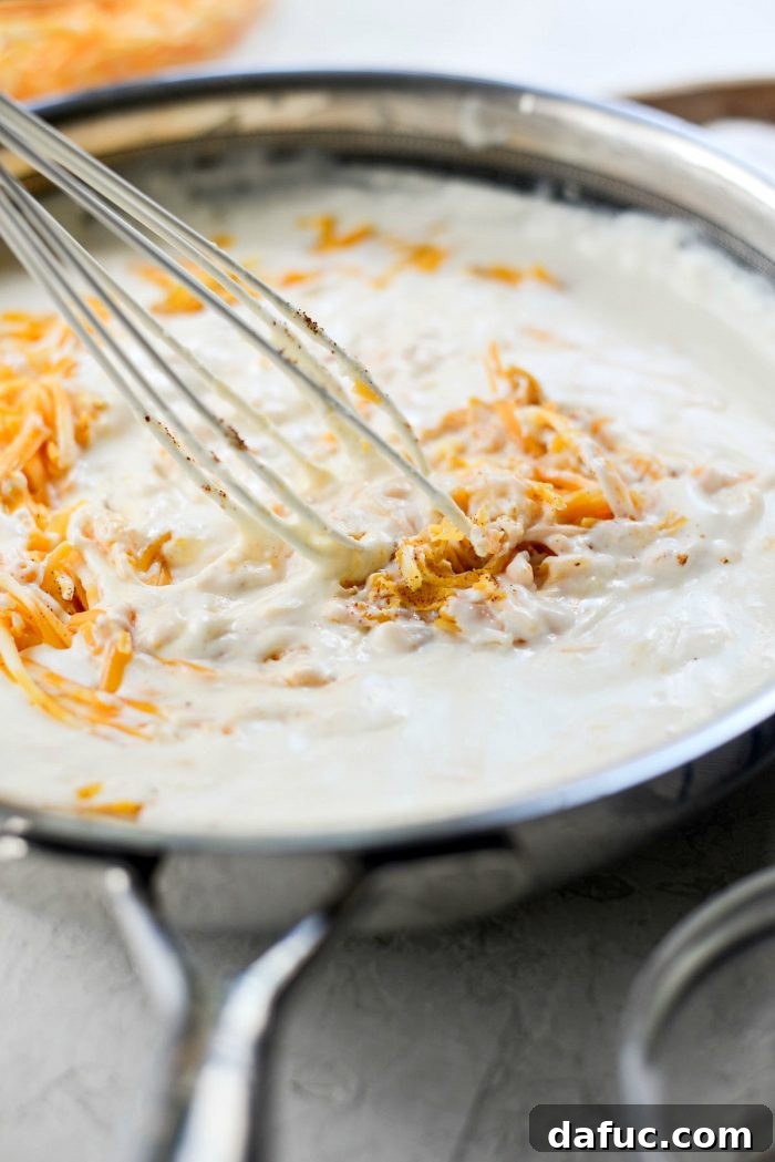 Adding Cheese, Dry Mustard, Paprika, Salt, and Pepper to Mac and Cheese Sauce