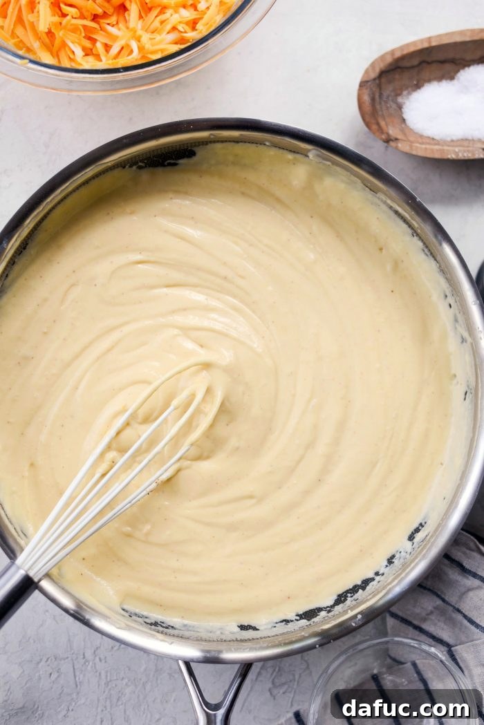 Stirring Cheese Sauce until Smooth for Homemade Mac and Cheese