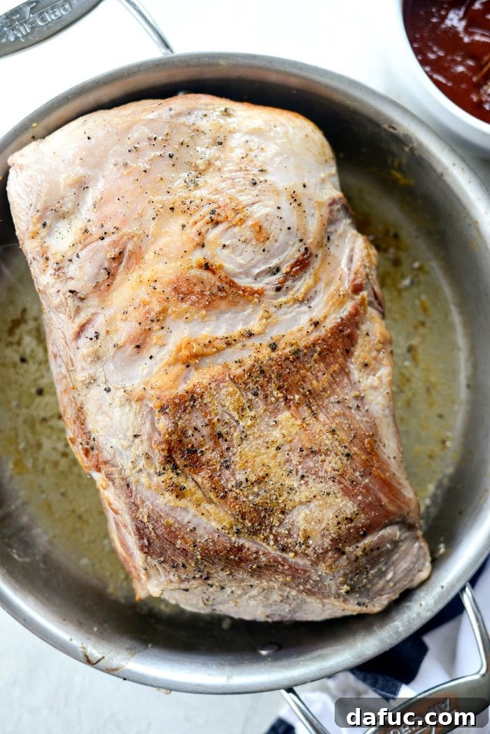 Searing pork shoulder in a hot skillet