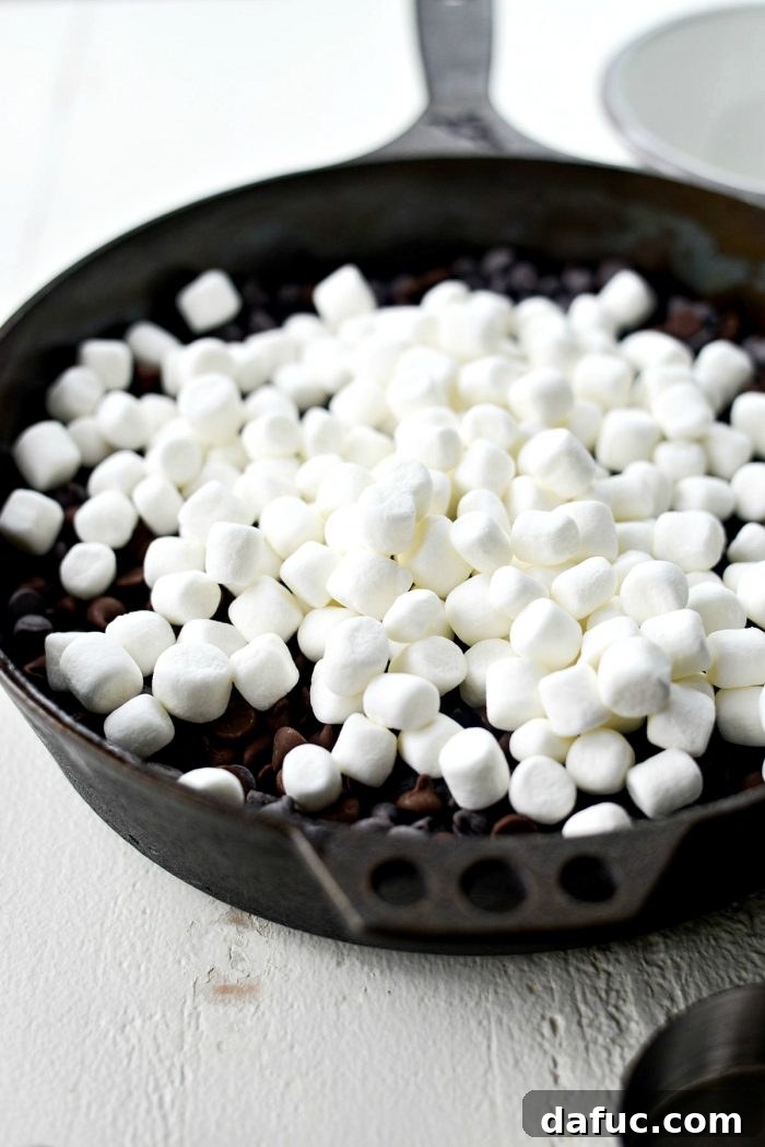 Gooey Campfire Skillet Dessert 7 Semi-sweet and milk chocolate chips spread evenly in a cast iron skillet.