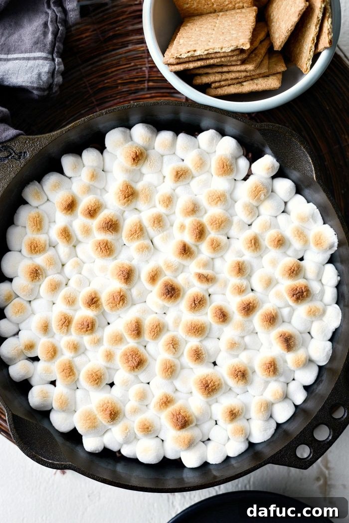 Gooey Campfire Skillet Dessert 9 Mini marshmallows covering chocolate chips in a cast iron skillet, ready for baking.