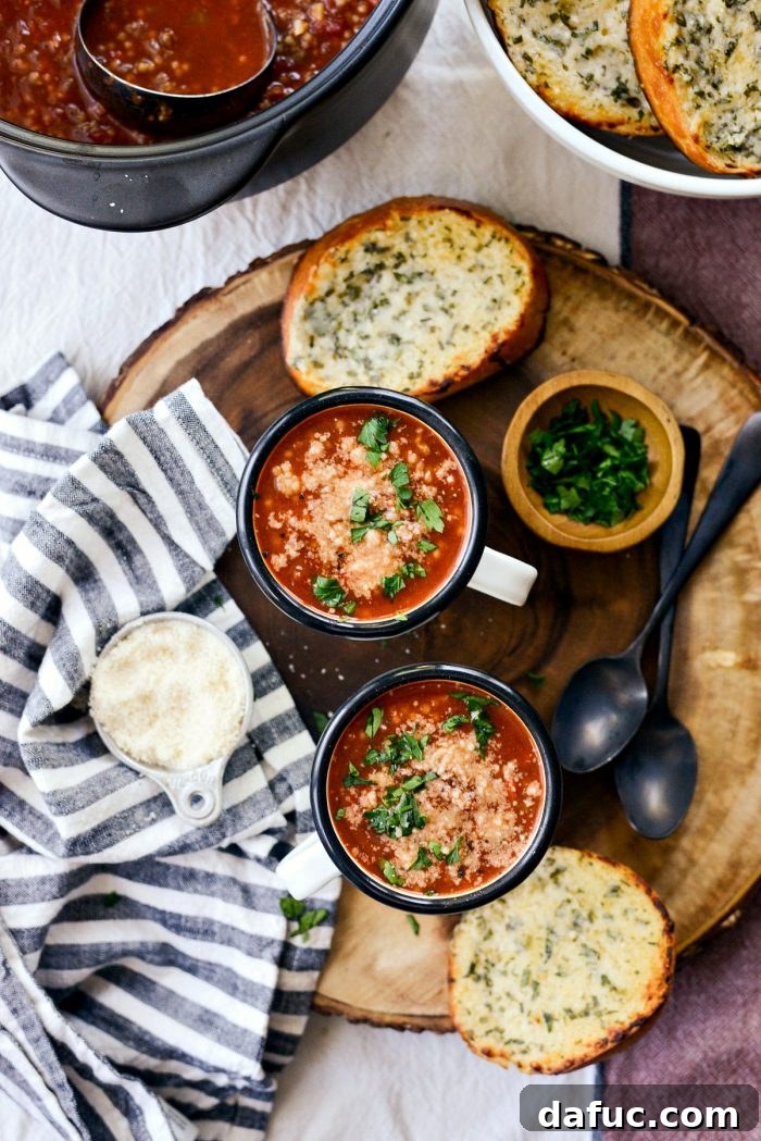 An overhead shot showcasing the comforting Beef Tomato Ancini de Pepe Soup in a mug with a spoon, ready to be enjoyed as a warm meal.