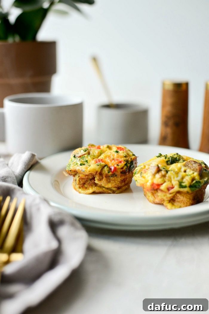 A serving of two Sausage Potato Mini Frittatas with a fork