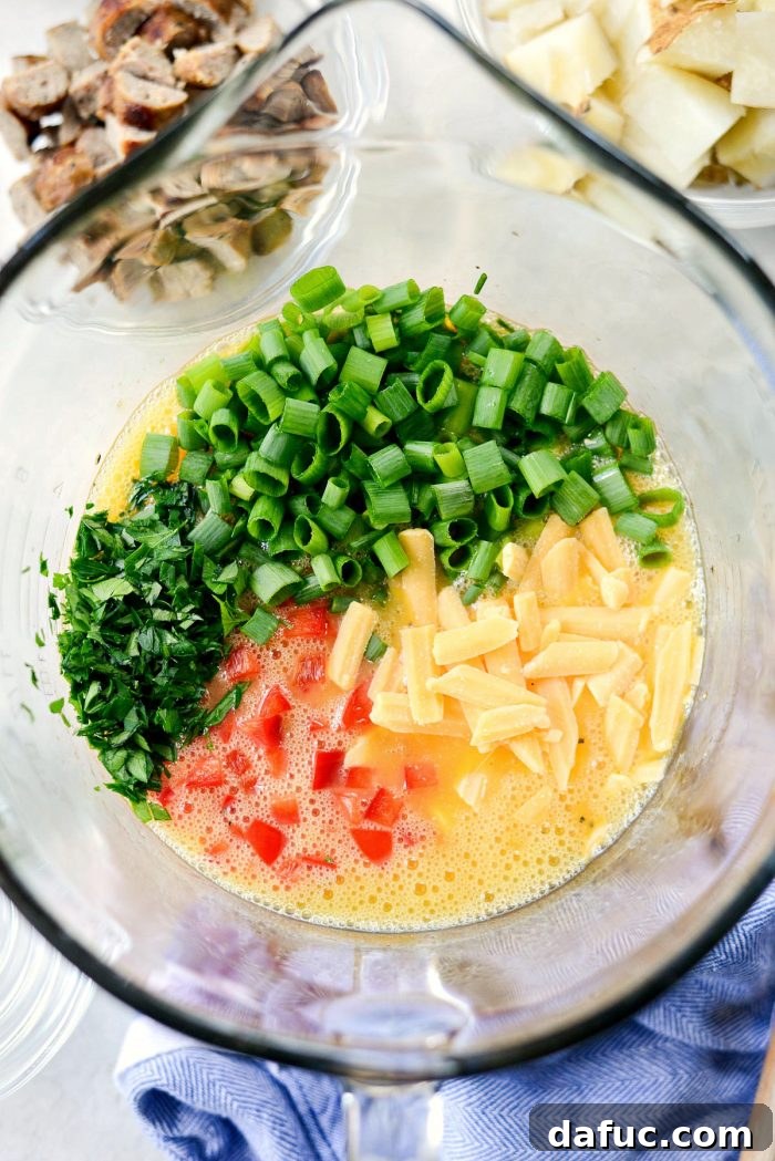 Adding diced red bell pepper, green onions, and cheese to the egg mixture