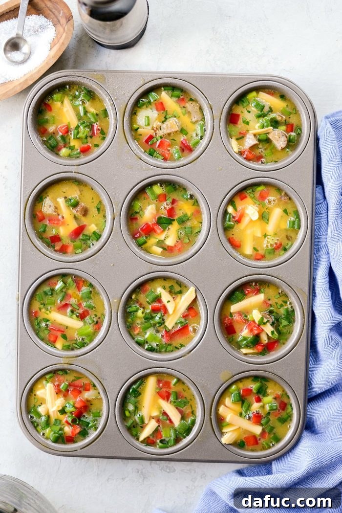 Pouring the egg mixture over the potatoes and sausage in the muffin tin