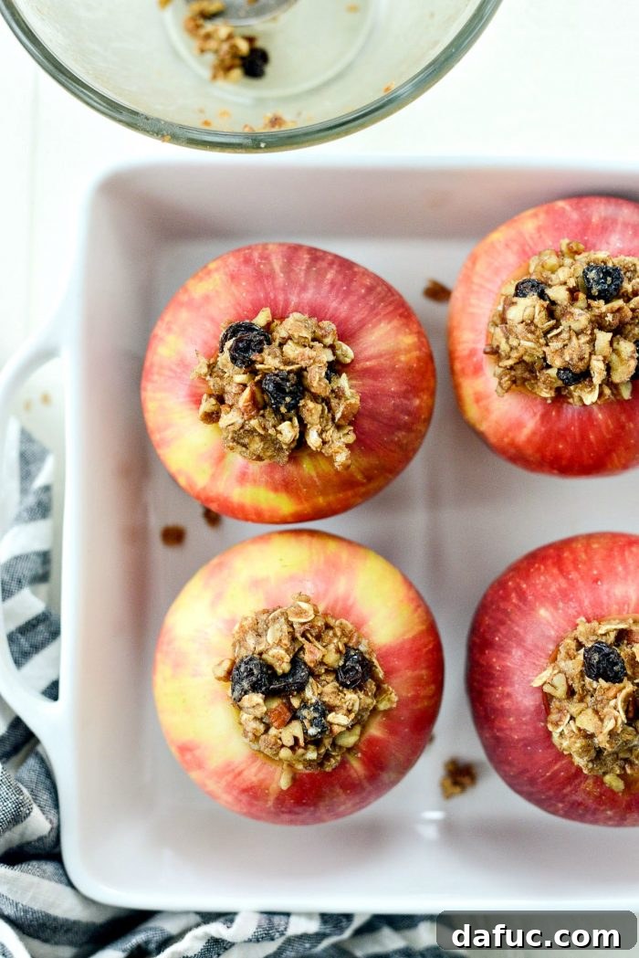 Spoon oat crumble filling into hollowed-out apples