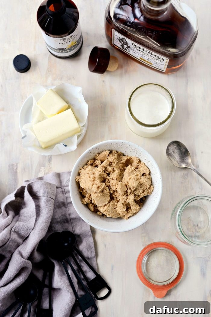 Ingredient shots for Homemade Butter Rum Sauce, featuring butter, brown sugar, heavy cream, and dark rum on a rustic surface.