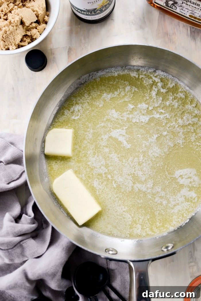 Measuring out light brown sugar, a key ingredient for the sweet base of the Homemade Butter Rum Sauce.