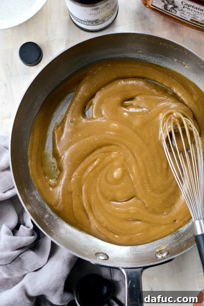 Adding light brown sugar to melted butter, beginning the caramelization process for butter rum sauce.