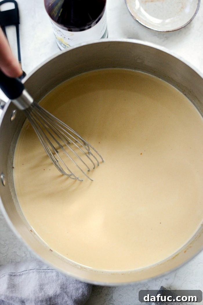 Cozy Pumpkin Chai Dream 8 Milk being poured into the pumpkin spice mixture in a saucepan