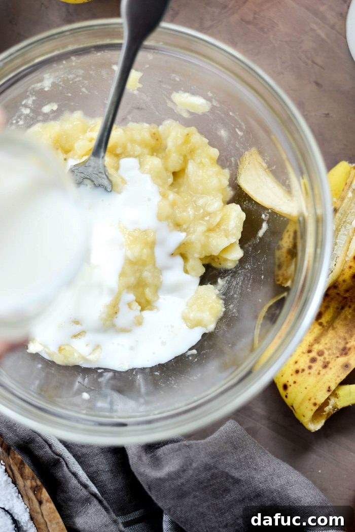 Golden Maple Bourbon Banana Pudding Cake 8 Mashing a ripe banana for the cake batter