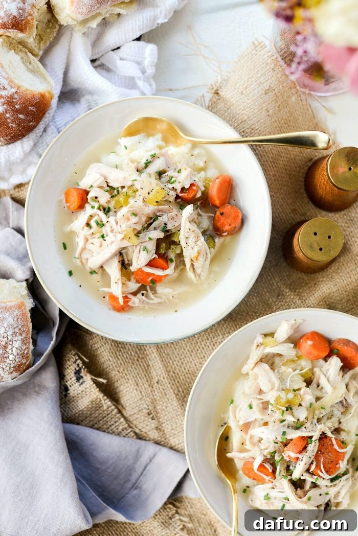 Final plated slow cooker chicken and vegetables with soft rolls