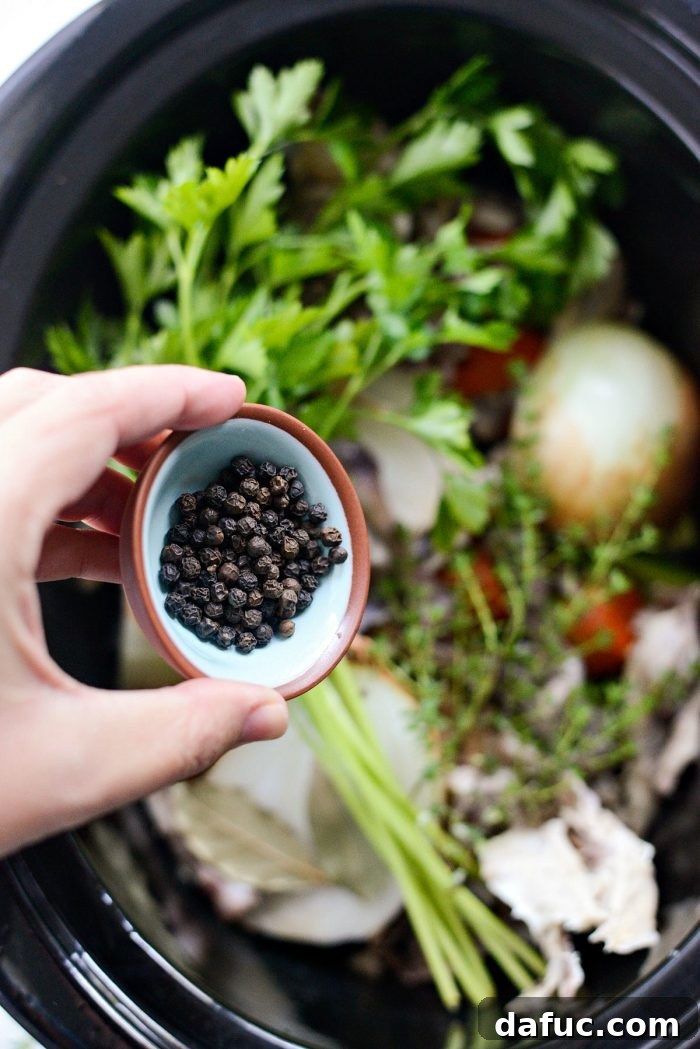 Deeply Flavored Slow Cooker Chicken Broth 7 Adding black peppercorns to slow cooker chicken stock