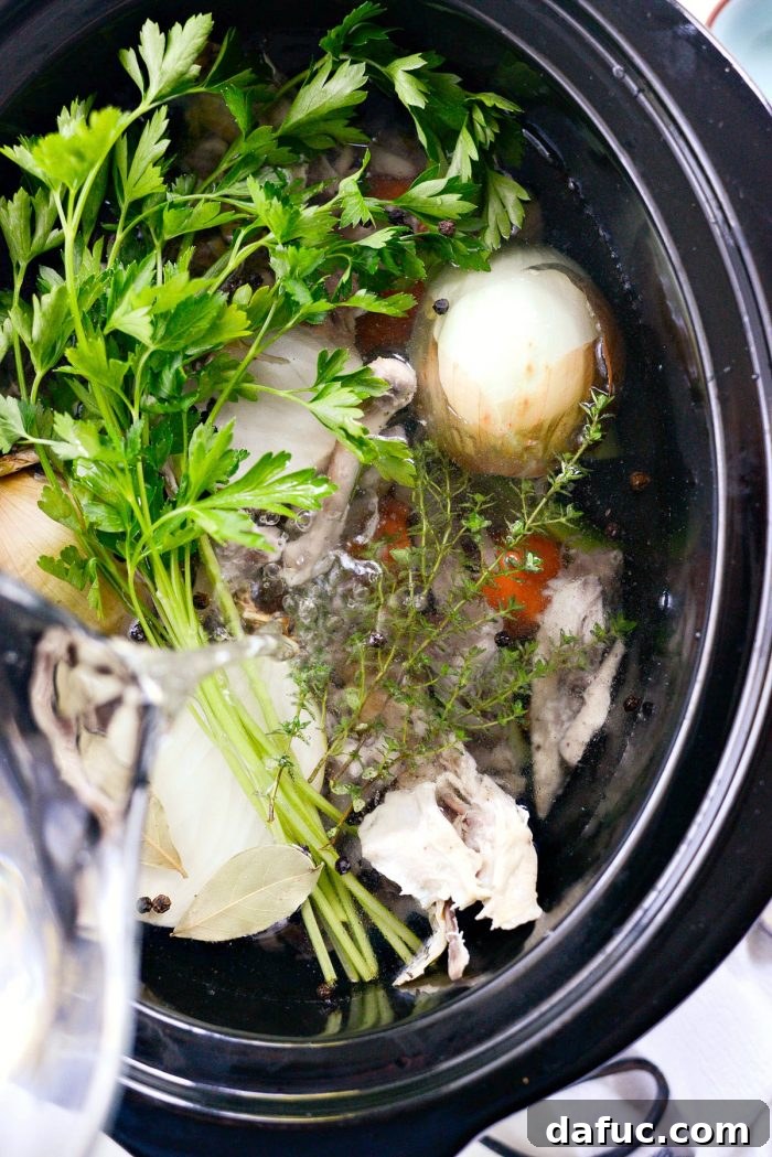 Low & Slow Chicken Broth 9 Adding filtered water to the slow cooker, ensuring a clean base for the homemade chicken stock. #filteredwater #stockbase #cleancooking