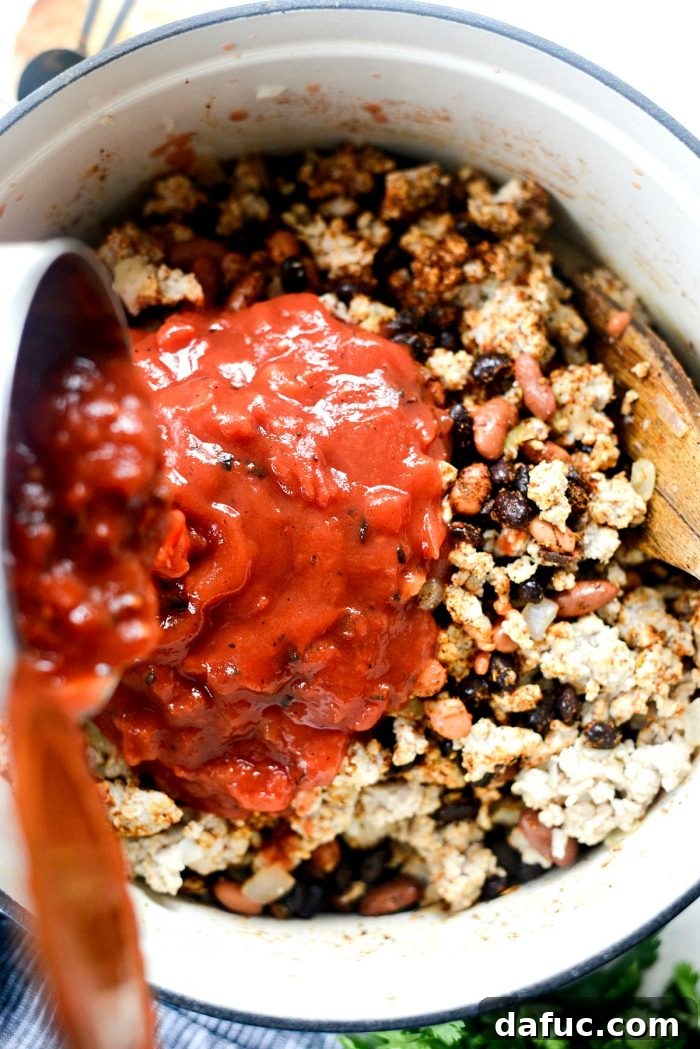Adding fire-roasted tomatoes and tomato sauce to the chili base