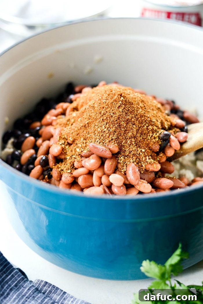 Adding southwest seasoning and drained beans to the browned chicken
