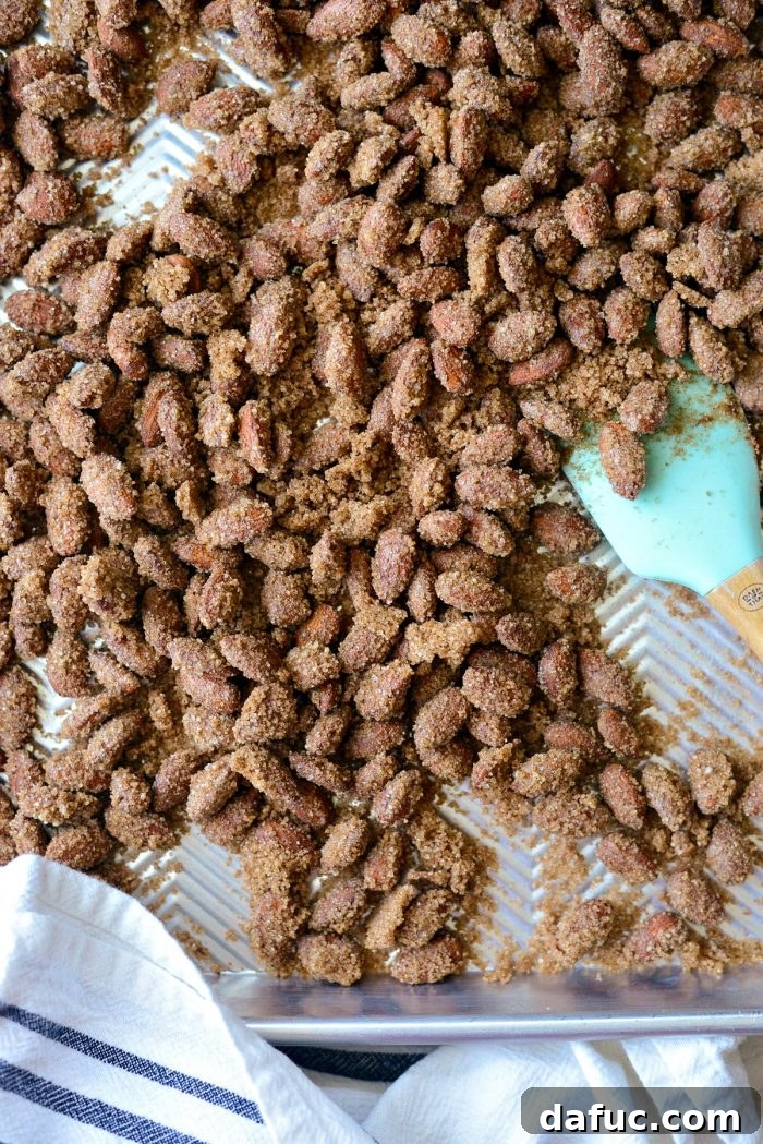 Irresistible Cinnamon Sugar Almonds 12 Baking sheet with cinnamon sugar almonds after the first 10 minutes in the oven, ready for tossing.