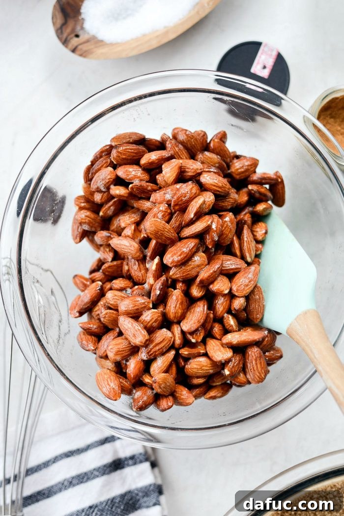 Irresistible Cinnamon Sugar Almonds 8 Pure vanilla extract being added to the foamy egg white mixture in a bowl.