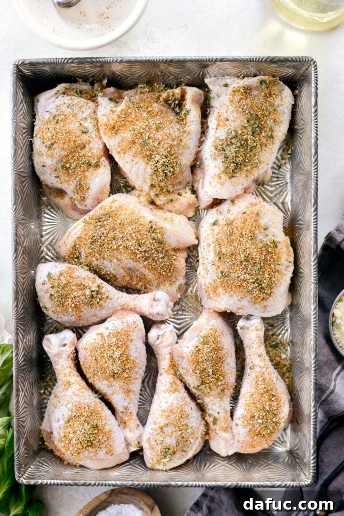 Crispy Garlic Parmesan Baked Chicken 5 Baking pan with seasoned chicken thighs and drumsticks, ready for the oven. Prepping for a delicious Parmesan Garlic Baked Chicken.