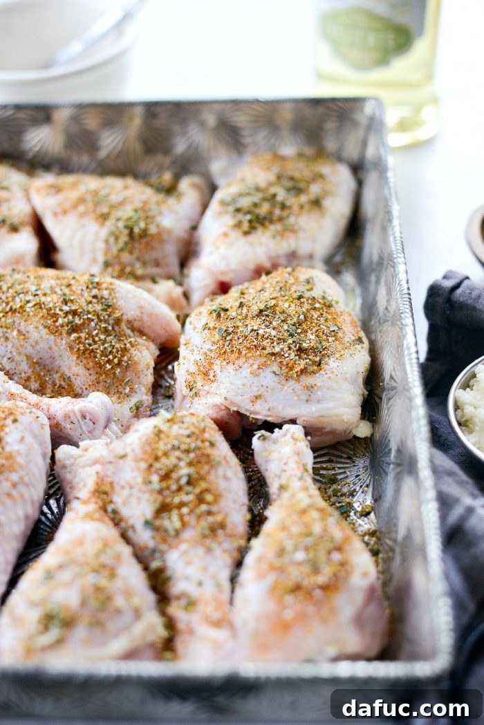 Crispy Garlic Parmesan Baked Chicken 6 Seasoned chicken pieces in a baking pan, close-up, illustrating the readiness for baking in the oven.