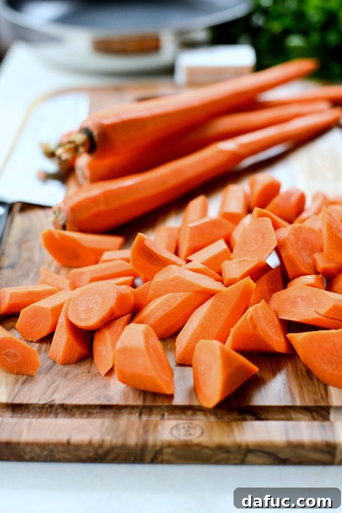 Fresh ingredients laid out for garlic butter roasted carrots: carrots, butter, garlic, salt, pepper, and parsley.