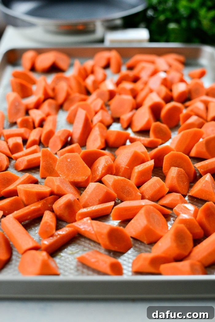 Chef's hands demonstrating the roll cut technique on fresh carrots, creating angled pieces.