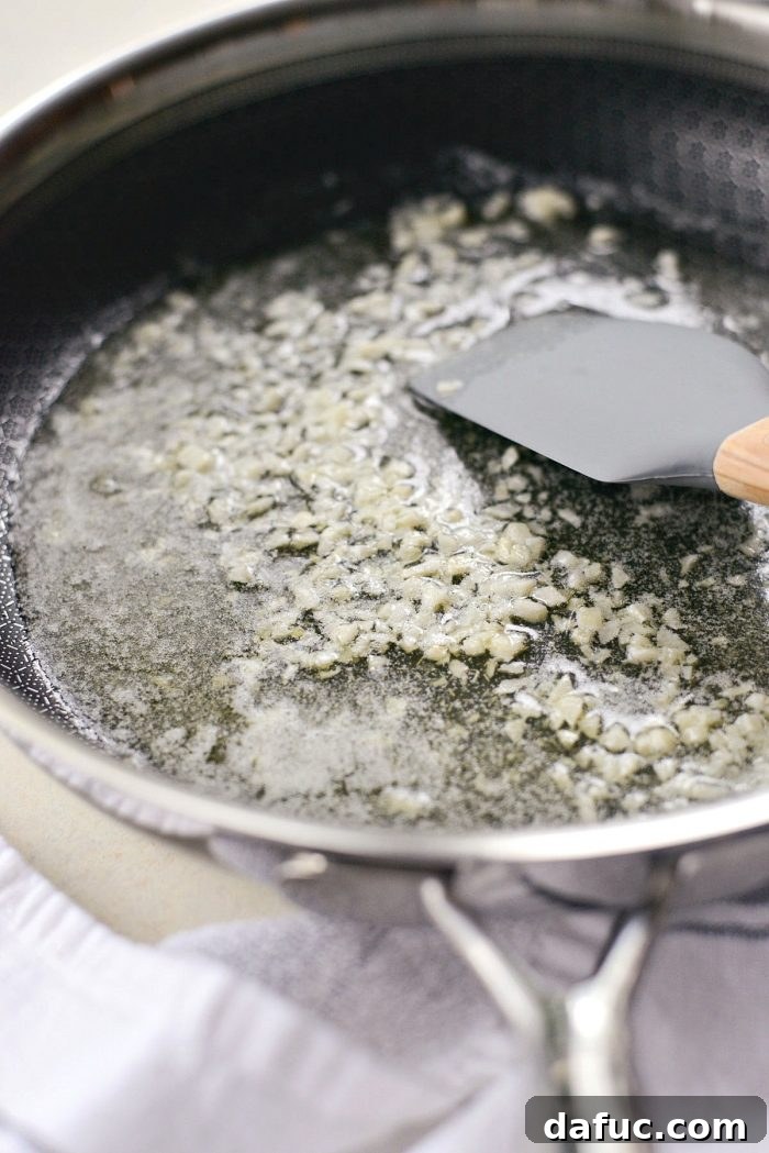 Butter, minced garlic, and kosher salt melting in a deep-sided skillet over medium-low heat.