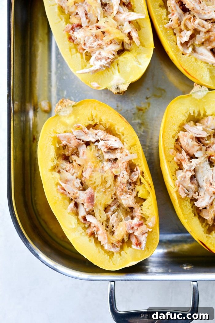 Chicken Bacon Jalapeño Spaghetti Squash filling divided equally among roasted squash halves, ready for toppings and final baking.
