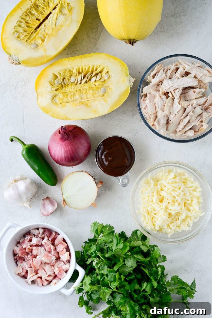 Ingredients for Chicken Bacon Jalapeño Spaghetti Squash laid out, including spaghetti squash, chicken, bacon, BBQ sauce, jalapeños, and cheese.