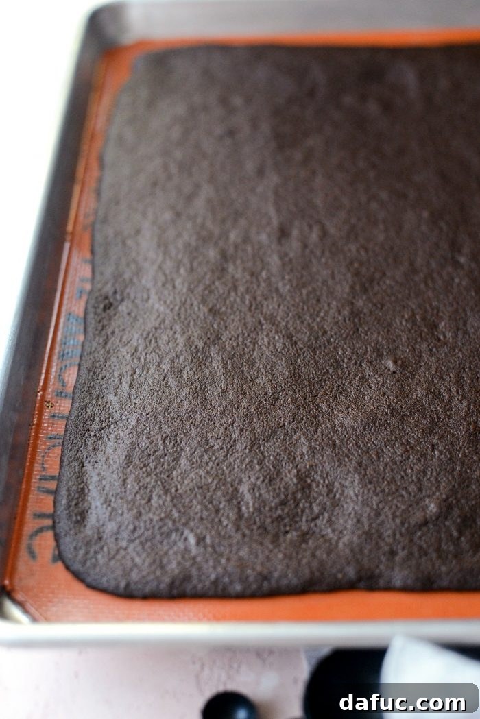 Gourmet Brownie Crisps 10 Spreading thin brownie batter onto a silicone mat on a baking sheet