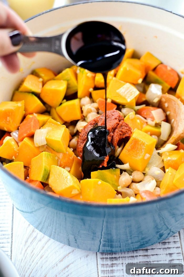 Creamy Kabocha Thai Red Curry 9 Stirring vegetables and spices in the Dutch oven