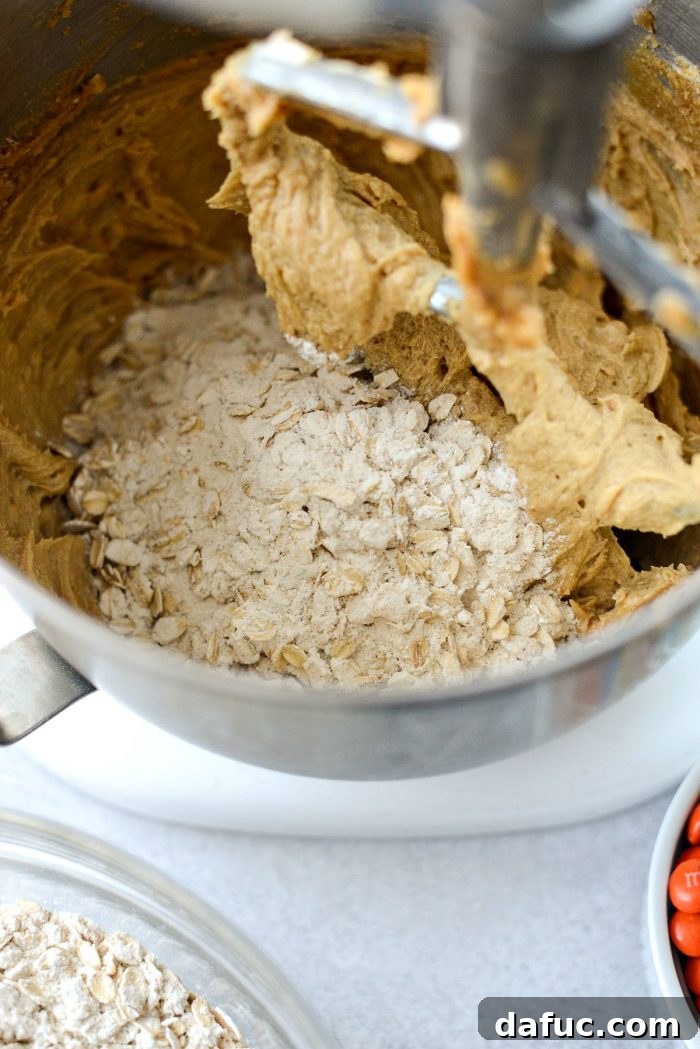 Gradually adding the flour and oat mixture to the wet ingredients