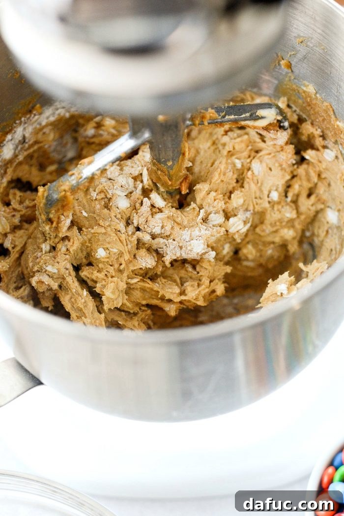 Mixing the cookie dough until just combined after adding dry ingredients