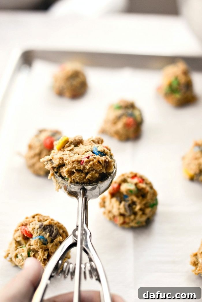 Using a cookie scoop to portion dough onto a parchment-lined baking sheet